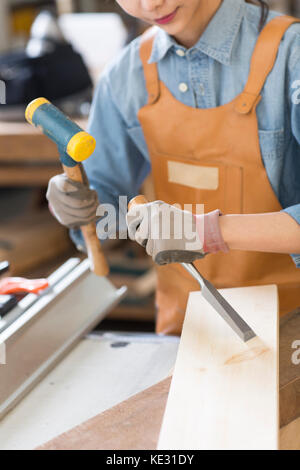 Junge weibliche Schreiner auf ihre Arbeit konzentrieren. Stockfoto