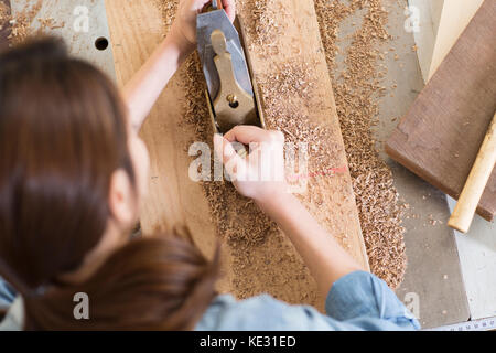 Zurück Portrait von jungen weiblichen woodworker auf ihre Arbeit konzentrieren. Stockfoto