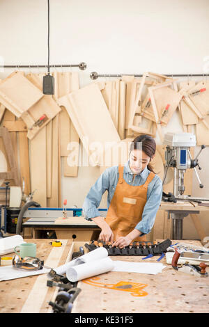 Junge weibliche Schreiner auf ihre Arbeit konzentrieren. Stockfoto