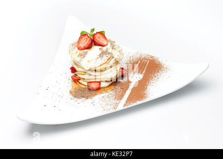 Süße Nachspeise mit Erdbeeren und Sahne, auf einer Platte mit Schokolade Pulver eingerichtet Stockfoto