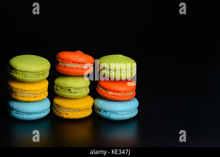 Stapel von bunte Macarons isoliert auf Schwarz mit Reflektion Stockfoto