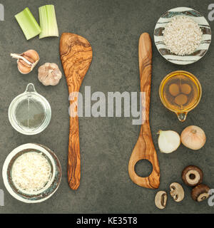 Italienische Lebensmittel Konzept und Menü Design. Pilze risotto Zutaten auf dunklen rustikalen Stein Hintergrund mit Flach Platz und zu kopieren. Stockfoto