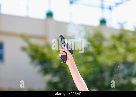 Hand mit schreckschusspistole in der Schule Garten Stockfoto
