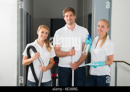 Gruppe der Glückliche junge Hausmeister, Reinigung Ausrüstungen Stockfoto