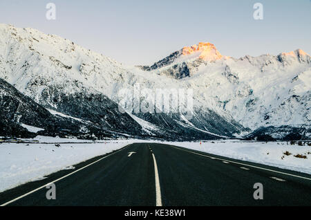 Blick auf den majestätischen Aoraki Mount Cook mit der Straße zum Mount Cook Village. Im Winter in Neuseeland übernommen. Stockfoto