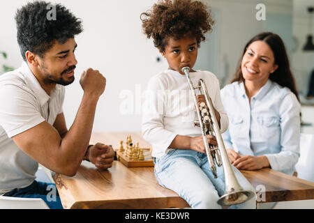 Stolze Eltern ihrem Kind beobachten Trompete spielt. Stockfoto