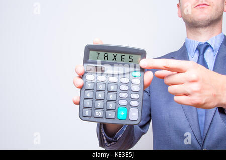 Junge Unternehmer, die auf Rechner. Steuern Geschäftskonzept Taschenrechner mit Steuern auf Display Stockfoto