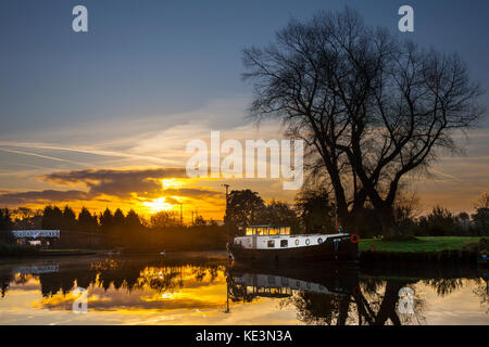 Rufford, Lancashire. 18 Okt, 2017. UK Wetter. Blauer Himmel über der Leeds Liverpool canal bringen ländliche Temperaturen von bis zu 7 C für die Bewohner von St. Mary's Marina. Bunte sunrise Highlights Flugzeuge Trails, über dieses beliebten Wasserstraße der längste Kanal in Nordengland. Einige Schätzungen behaupten, dass bis zu 15.000 Menschen flott Leben auf britischen Wasserstraßen. Die Organisation ist verantwortlich für die meisten der Binnenschifffahrt im Land, mit über 6.500 seiner 32.000 Liegeplätze für lizenzierte Boote als Wohnungen genutzt werden. Credit: MediaWorldImages/Alamy leben Nachrichten Stockfoto