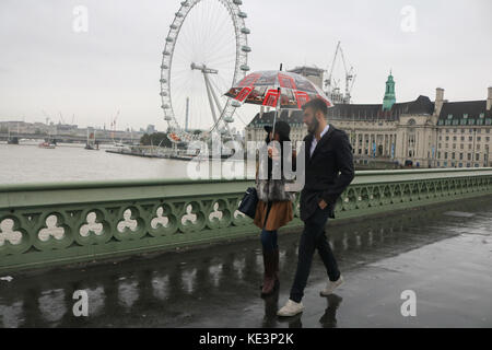 London, Großbritannien. 18 Okt, 2017. Fußgänger und touristische Unterschlupf vor dem Regen Nieselregen auf die Westminster Bridge in einer kalten, feuchten Tag in der Hauptstadt der Credit: Amer ghazzal/alamy leben Nachrichten Stockfoto