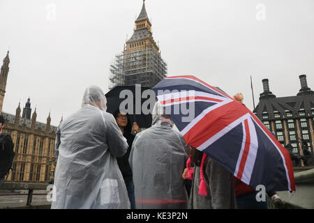 London, Großbritannien. 18 Okt, 2017. Fußgänger und touristische Unterschlupf vor dem Regen Nieselregen auf die Westminster Bridge in einer kalten, feuchten Tag in der Hauptstadt der Credit: Amer ghazzal/alamy leben Nachrichten Stockfoto