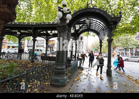 Seattle, USA. 18 Okt, 2017 Seattle, Washington: die Besucher durch das Eisen Pergola am Pioneer Square als der erste Sturm der Saison Wimpern Seattle mit starkem Wind und Regen. Der nationale Wetterdienst hat eine hohe wind Warnung in Wirkung und Starkregen Beratung durch das Wochenende für die meisten westlichen Washington. Credit: Paul Christian Gordon/alamy leben Nachrichten Stockfoto