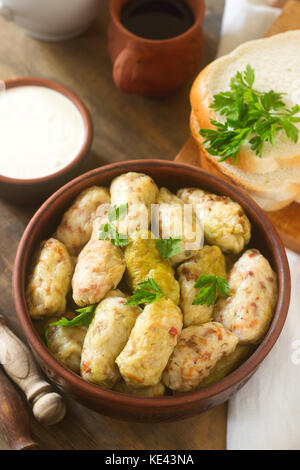 Kohlrouladen mit saurer Sahne, Brot und Wein serviert. Traditionelle moldawische oder rumänischen sarmale Teller, traditionellen Russischen oder Ukrainischen golubtsy. selec Stockfoto