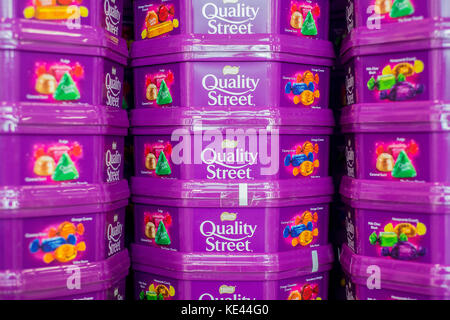 Dosen Quality Street Pralinen selbst dem Regal in einem britischen Supermarkt gestapelt Stockfoto