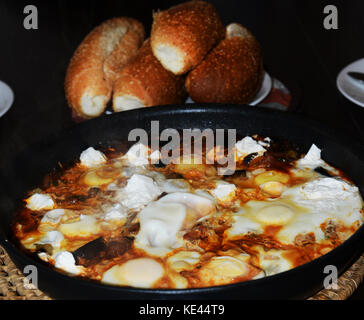 Shakshuka serviert mit frischem Brot. Shakshuka ist ein beliebtes Frühstück Gericht in Israel. Das Gericht stammt aus Tunesien in Nordafrika. Stockfoto