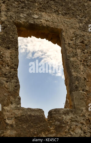 Blauer Himmel mit weißen Wolken, die durch ein Fenster eines zerstörten Mauer gesehen Stockfoto