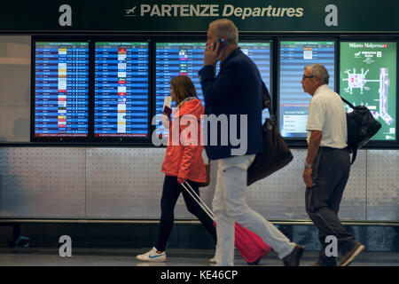 Mailand, Italien - 9. Oktober 2017: Flughafen, Leute gehen zu den Abflug boards im Hintergrund Stockfoto