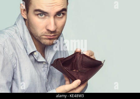 Bussinessman Holding eine leere Brieftasche in der Hand. der Kerl zeigt den Mangel an Geld Stockfoto