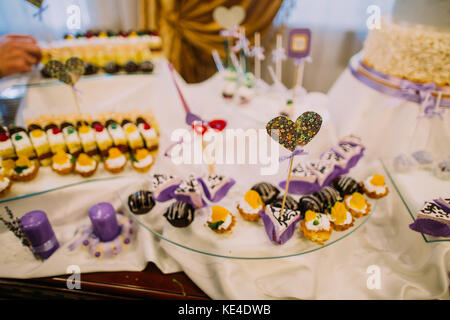 Schönes Herz auf dem Stick ist in der Cupcake platziert. das dessert Hochzeit Tisch. Stockfoto