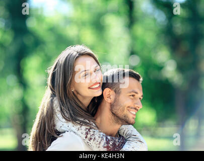 Paar Mann und Frau Spaß Huckepack im Park. Glücklich lächelnde Freund und Freundin genießen jede andere Firma und schönen Sommer weath Stockfoto