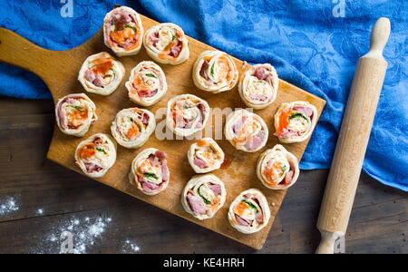 Pizza brötchen Gebäck auf einem hölzernen Schneidebrett Stockfoto