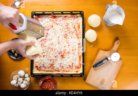 Mann Gitter Käse auf der Pizza, Pizza. Stockfoto