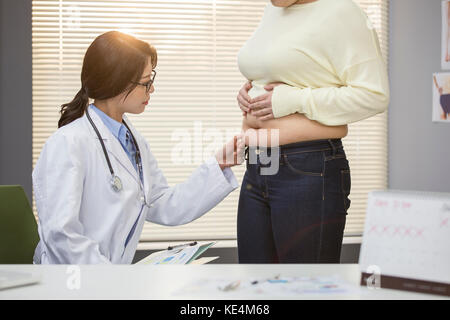 Eine junge Ärztin prüfen Fett Frau an Adipositas Klinik Stockfoto