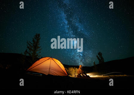 Mann Tourist in der Nähe seiner camp Zelt in der Nacht. Stockfoto