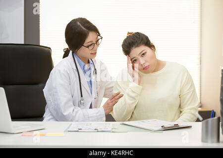 Lächelnd weibliche Arzt Förderung Fett Frau an Adipositas Klinik besorgt Stockfoto