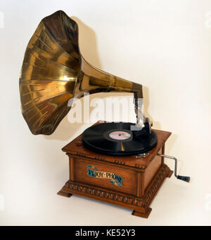 Früh Wind bis Grammophon mit grossen Horn an der rechteckigen Holzrahmen mit Griff. Reproduktion der 1900 s Modell. mit großen Messing Horn auf runden Holz- basis. Mit Tonarm. Gespielt Disc aufzeichnet. Stockfoto