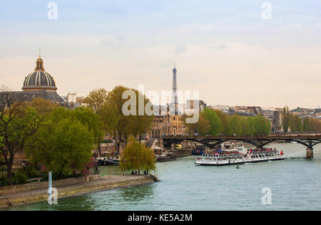 Paris, Frankreich, 28. April 2013: Eiffelturm und Tour Boote genannt Bateaux Mouches auf Seine diese Boote den Fluss für Sightseeing Touren segeln So Stockfoto