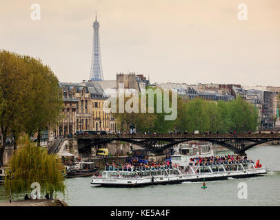 Paris, Frankreich, 28. April 2013: Eiffelturm und Tour Boote genannt Bateaux Mouches auf Seine diese Boote den Fluss für Sightseeing Touren segeln So Stockfoto