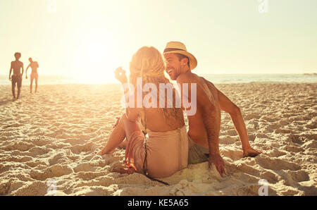 Junges Paar am sonnigen Sommerstrand entspannen Stockfoto