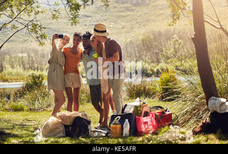 Junge Freunde machen Selfie mit dem Kameratelefon im sonnigen Sommer riverside Stockfoto