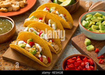 Leckere hausgemachte Chicken tacos Salsa Verde mit Avocado, Paprika, Sauerrahm und Kalk. Stockfoto