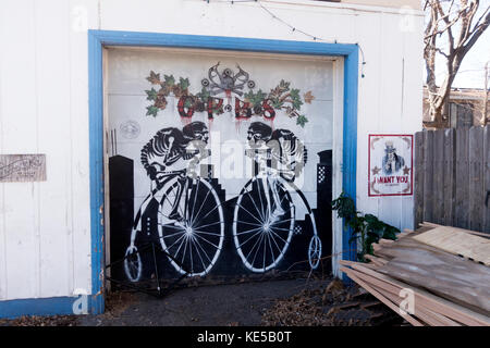 Grupo de comunicación Garagentor kunstvoll mit zwei Skelette auf Penny Farthing 1870 High wheeler Fahrräder eingerichtet. Minneapolis Minnesota mn Usa Stockfoto