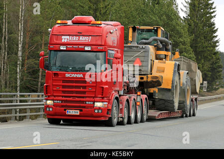 Mariehamn, Finnland - 23 April, 2016: Scania 164g transportiert schwere Volvo l350f Radlader als große Last entlang der Straße im Süden Finnlands. Stockfoto