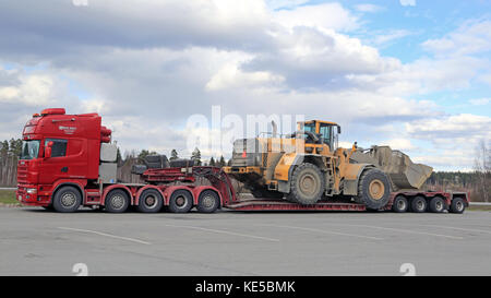 Mariehamn, Finnland - 23 April, 2016: Scania 164g Lkw stoppt bei Forssa Truck Stop während der übergroßen Transport von schweren Volvo l350f Radlader, Seite Stockfoto