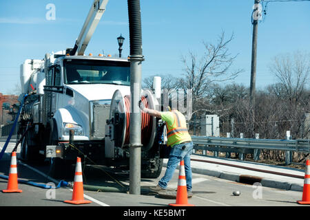 Mann Führung großen Vakuum auf einem Lkw in die Kanalisation für die Reinigung Ablagerungen. st paul minnesota mn Usa Stockfoto