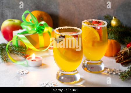 Hausgemachte weihnachten Cocktail pikanter Weißwein mit Zimtstangen, Anis Sterne und Stück Obst, in zwei Tassen serviert auf einem grauen Stein oder Schiefer. Stockfoto