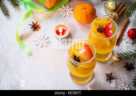 Hausgemachte weihnachten Cocktail pikanter Weißwein mit Zimtstangen, Anis Sterne und Stück Obst, in zwei Tassen serviert auf einem grauen Stein oder Schiefer. Stockfoto