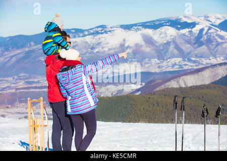 Vater, Mutter und Kinder haben Spaß und Spielen auf verschneiten Winter Spaziergang in der Natur. Stockfoto