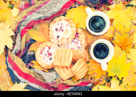 Herbst noch Leben, zwei Becher mit Kaffee in der Hand, Kuchen, Picknick im Herbst Park Stockfoto