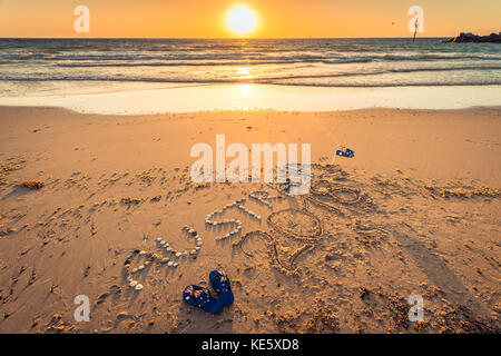 Australien 2018 Text mit Tangas, Flagge und Sonnenbrille am Strand bei Sonnenuntergang Stockfoto