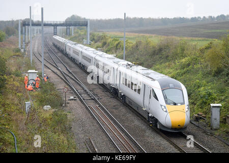 Ein neuer Elektrodiesel der Klasse 800 führt durch den nicht elektrifizierten Teil der Great Western-Hauptbahnstrecke in Richtung Westen zur denkmalgeschützten Brücke über die B4017 in Steventon, Oxfordshire, die die vollständige Elektrifizierung der Great Western-Hauptbahnstrecke verhindert, da sie zu niedrig ist. Stockfoto