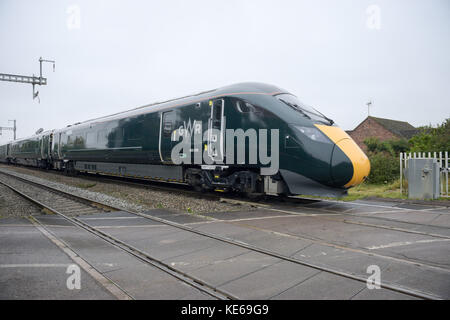 Ein neuer Elektrodiesel der Klasse 800 führt durch den nicht elektrifizierten Teil der Great Western-Hauptbahnstrecke in Richtung Westen zur denkmalgeschützten Brücke über die B4017 in Steventon, Oxfordshire, die die vollständige Elektrifizierung der Great Western-Hauptbahnstrecke verhindert, da sie zu niedrig ist. Stockfoto