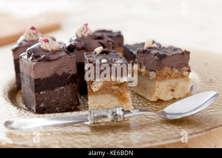 Verschiedene Arten von Raw vegan Kuchen auf einer Holzplatte in einem kleinen Gebäck. Stockfoto