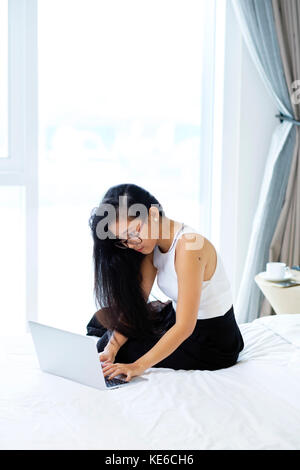 Eine asiatische Frau, die in ihrem Zimmer arbeitet Stockfoto