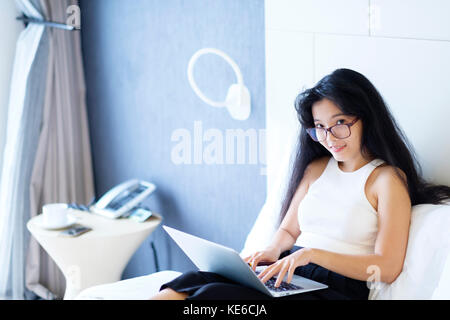 Eine asiatische Frau, die in ihrem Zimmer arbeitet Stockfoto