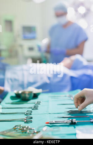 Krankenschwester, die chirurgische Instrumente auf einem Tablett im Operationssaal anordnet Stockfoto