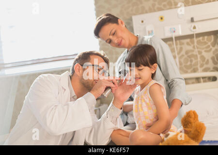 Männlich Arzt mit Otoskop im Ohr des Mädchens Patienten in Krankenhauszimmer Stockfoto